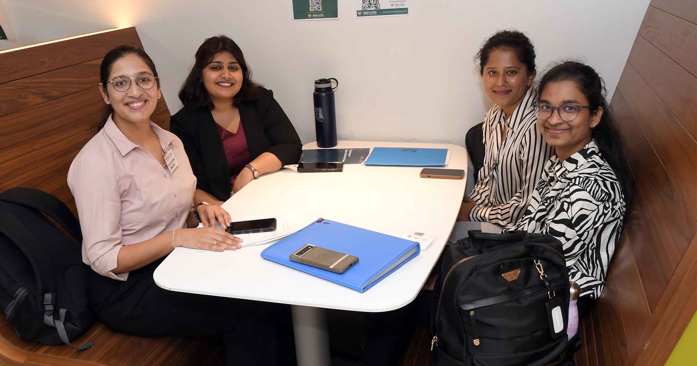 Group of students sitting in a study space smiling