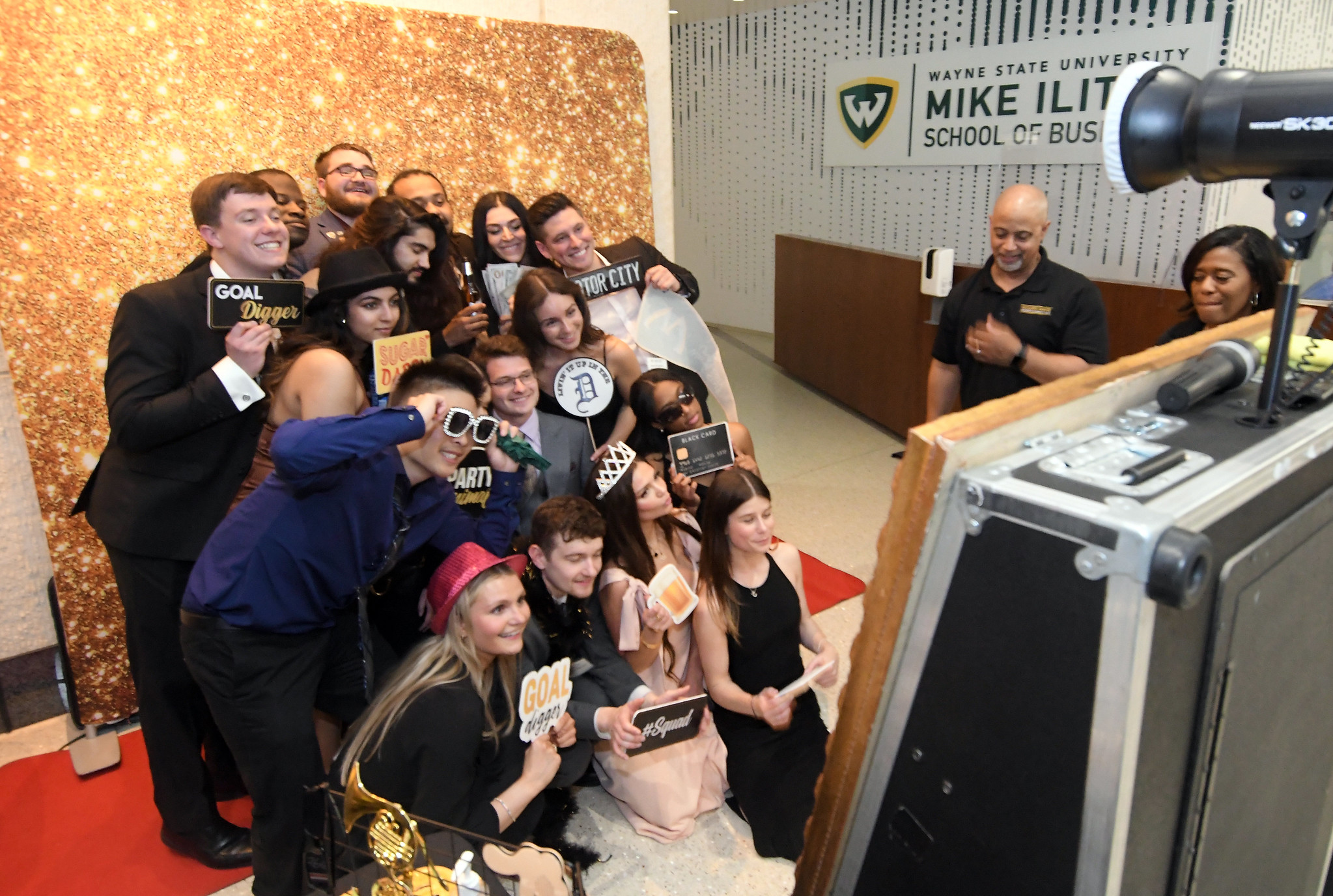 A group of Ilitch School students pose with a variety of props in front of a photo booth at the 2023 Gala