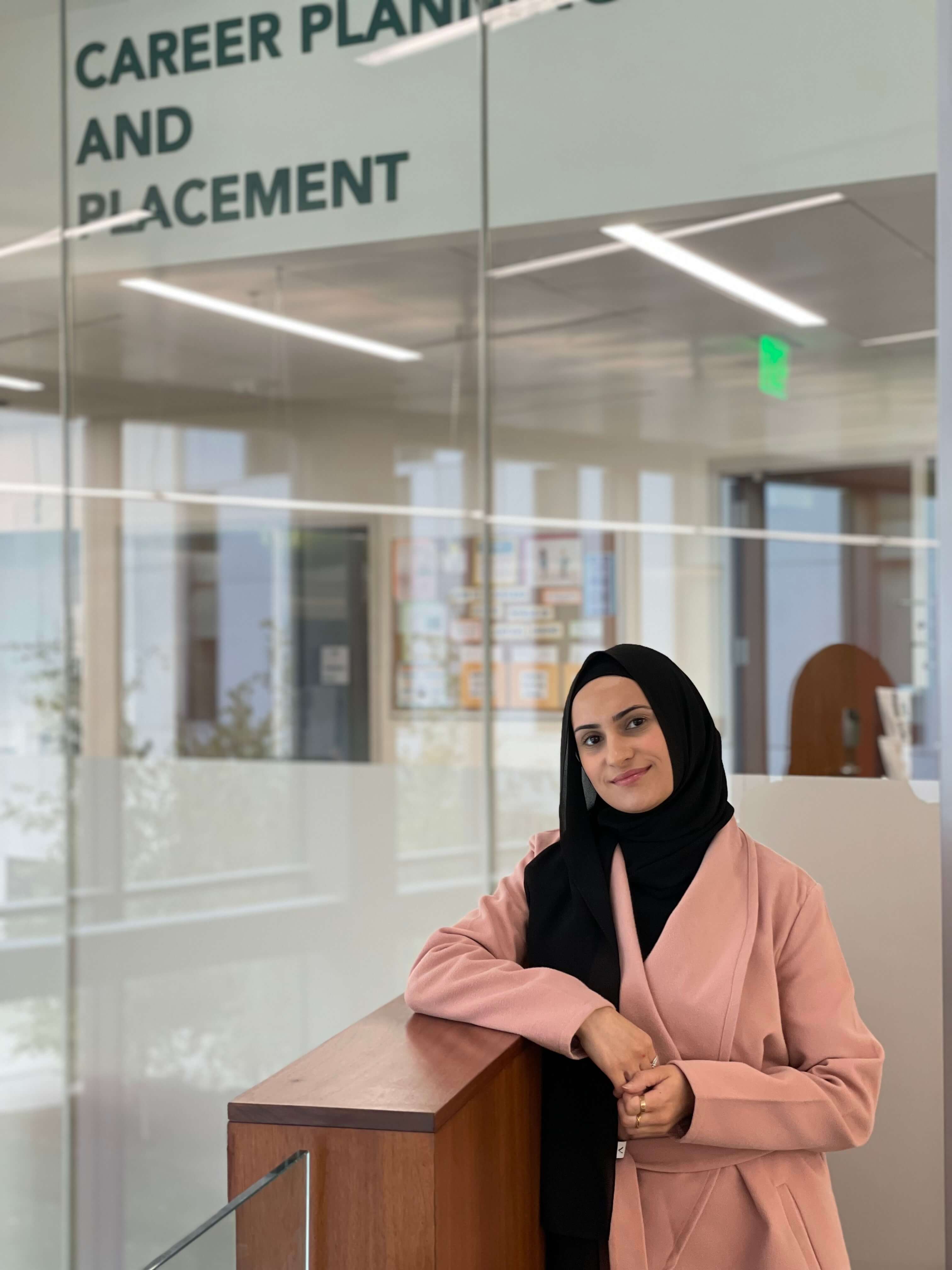 Female business student posing in front of the Career Planning and Placement office