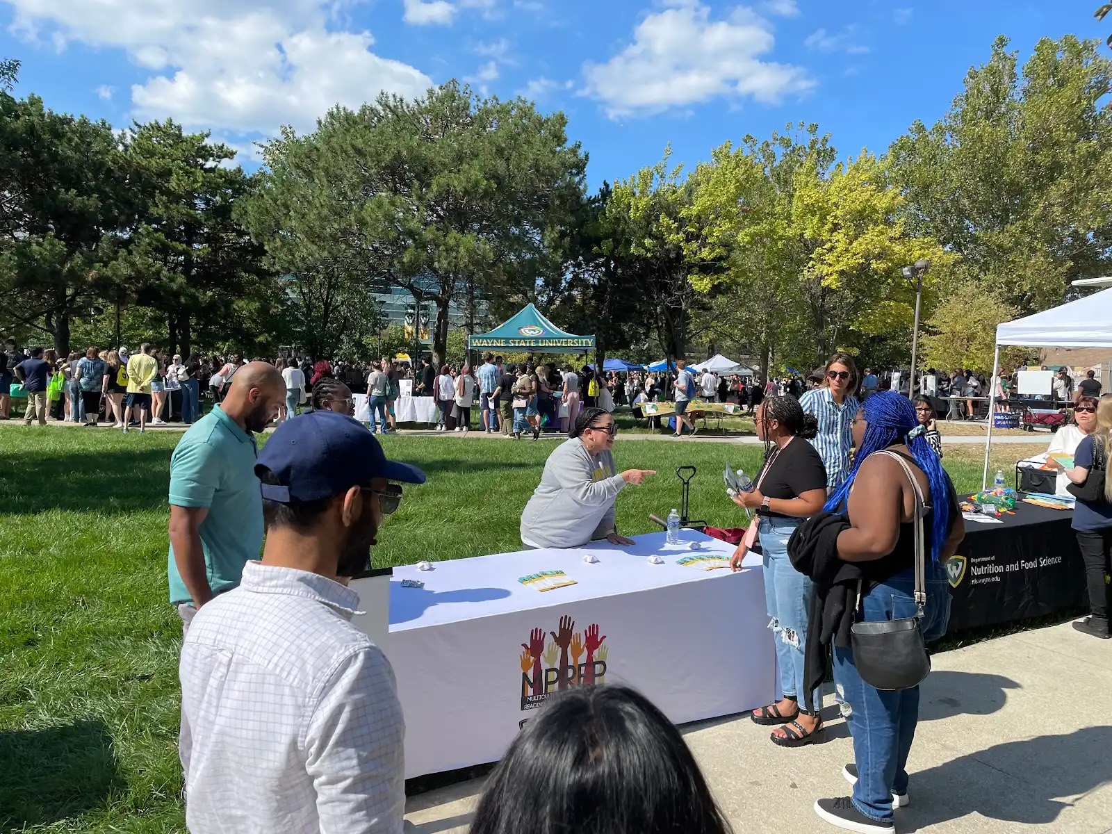 Students and staff members gather around the MPREP table at the Fall Fest event