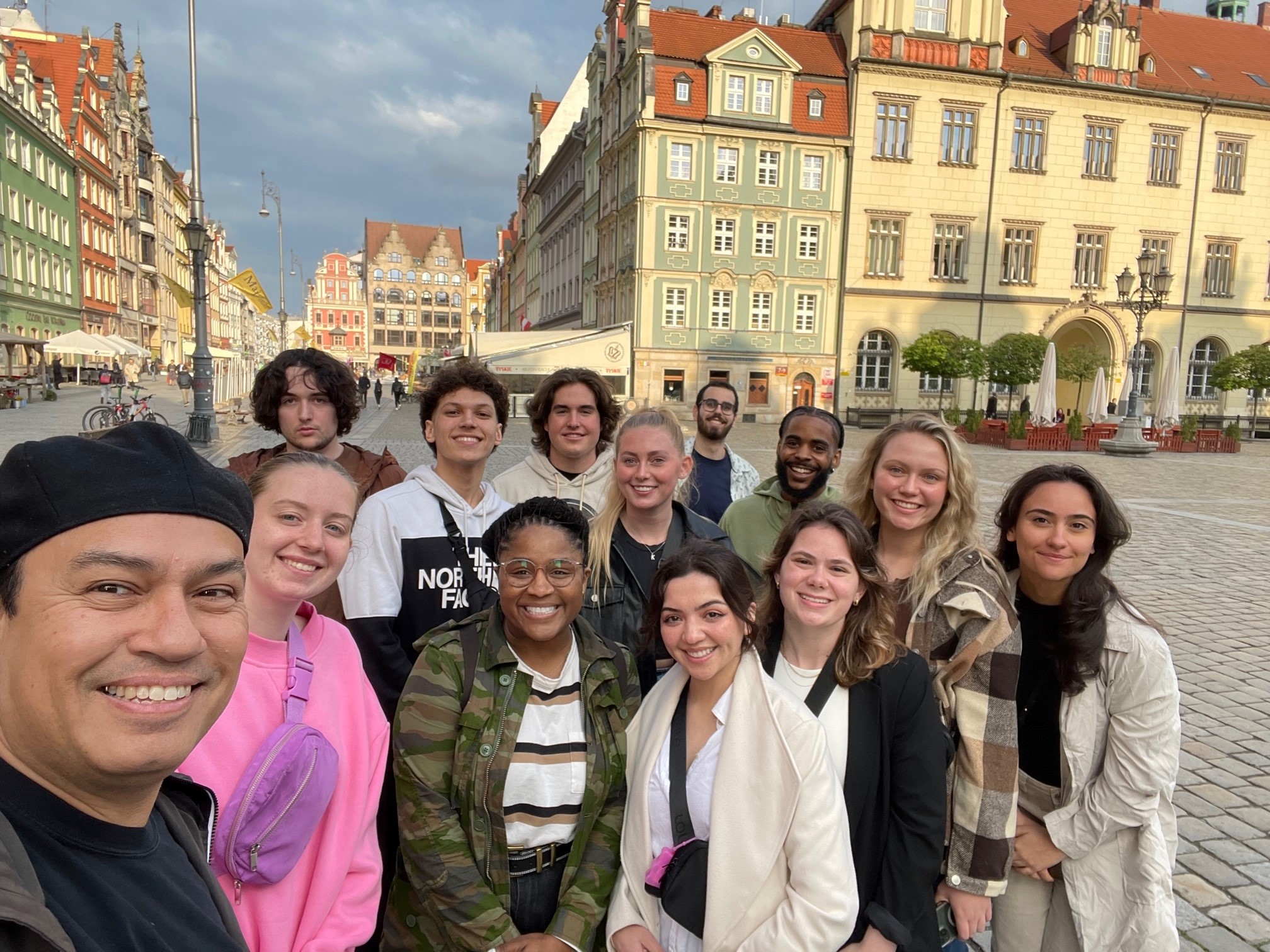 Ilitch School of Business students pose in Wrocraw Central Square in Poland during a study abroad trip